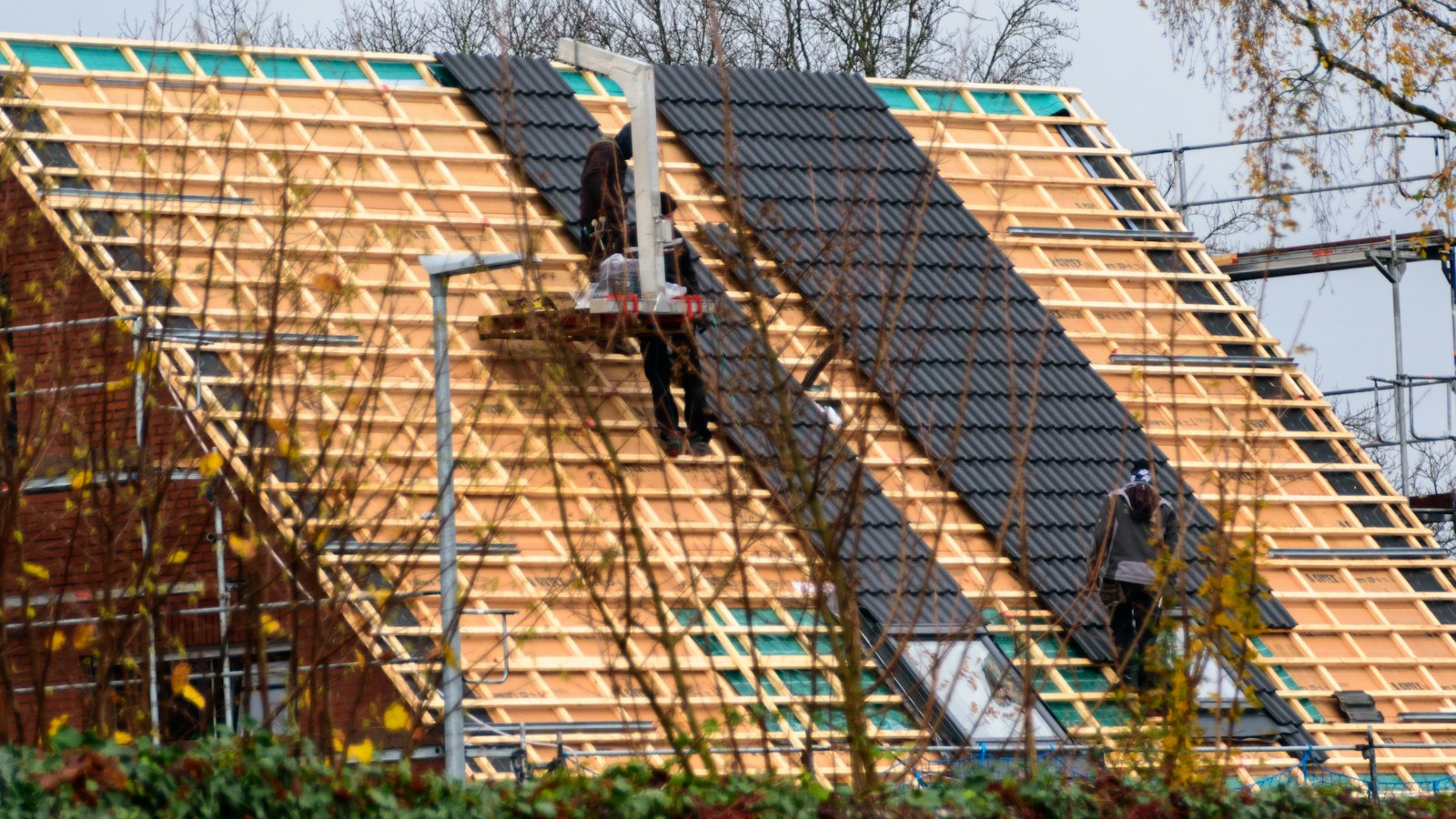 Roofing contractors installing tiles on a house, the kind of local business that benefits from local SEO